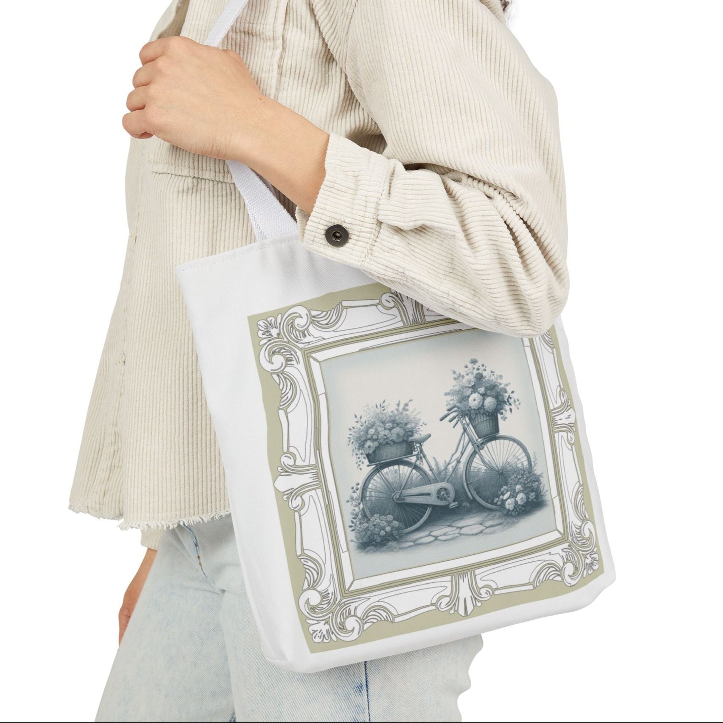 Person holding a tote bag with a bicycle and floral design on a white background